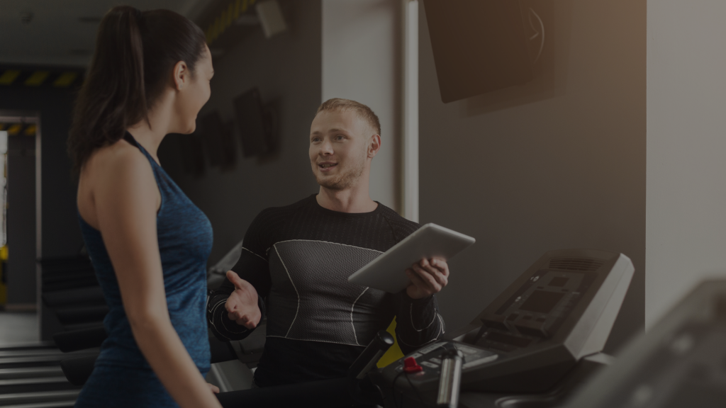 coach sportif qui parle à une dame sur un tapis