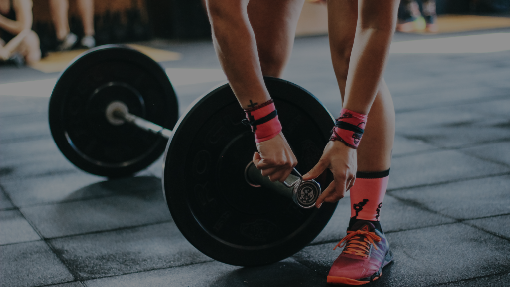 personne qui règle le poids sur une barre